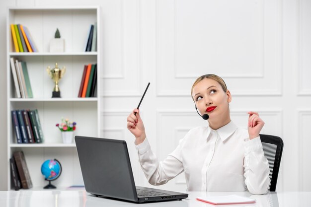 Service à la clientèle jolie fille blonde chemise de bureau avec casque et ordinateur en levant