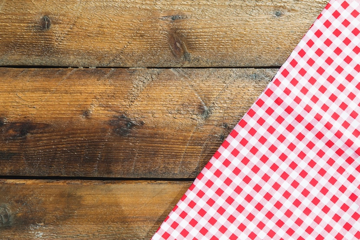 Photo gratuit serviette en damier rouge plié sur une table en bois