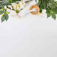 Photo gratuite serviette; sel; bougies; fleurs et feuilles sur une surface blanche