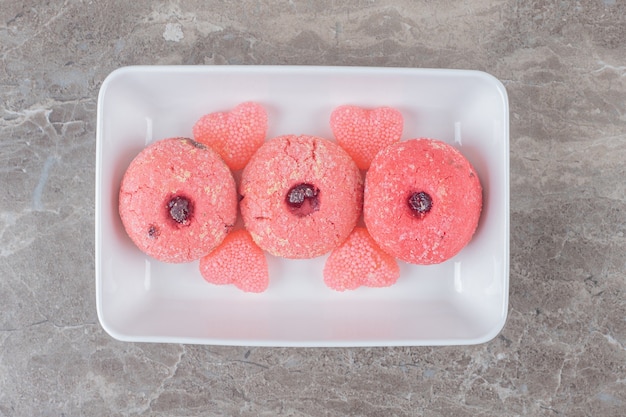 Servir des biscuits et des bonbons à la gelée sur un plateau sur une surface en marbre