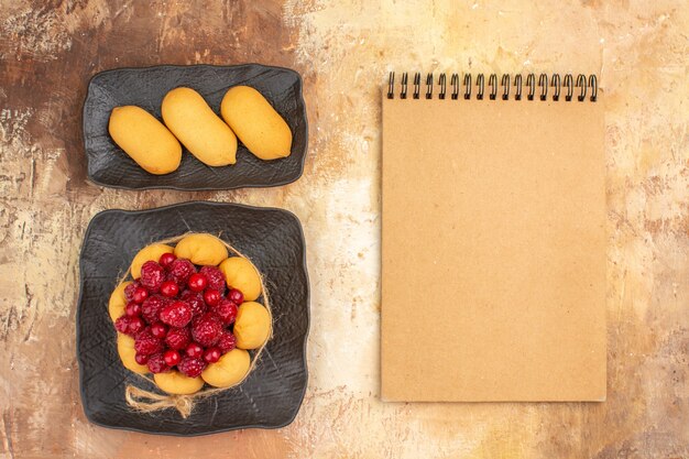 Set de table avec un gâteau-cadeau pour les invités et ordinateur portable sur table de couleurs mélangées