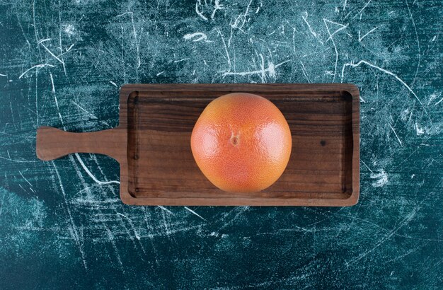 Seule orange savoureuse sur planche de bois.