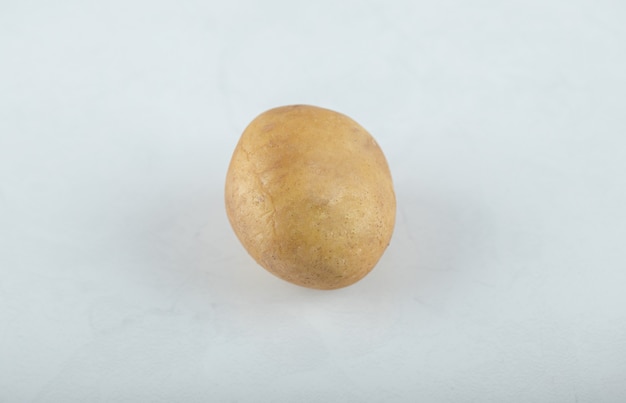 Photo gratuite une seule pomme de terre mûre crue sur fond blanc.