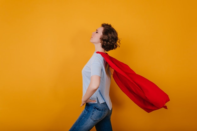 Shapely jeune femme avec manteau rouge en agitant debout