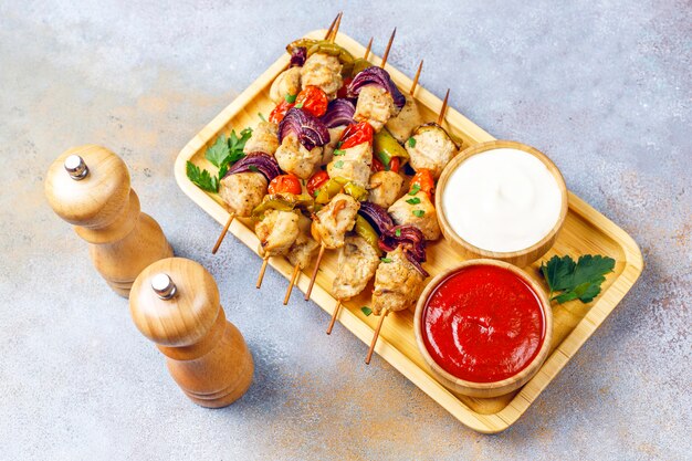Shish kebab au poulet avec légumes, ketchup, mayonnaise, vue du dessus