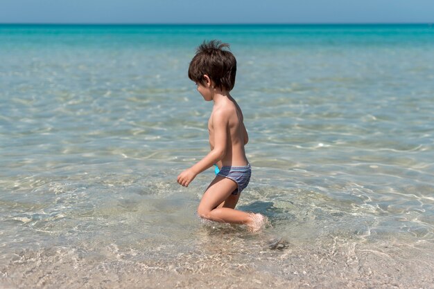 Sideview, garçon, plage, jouer, eau