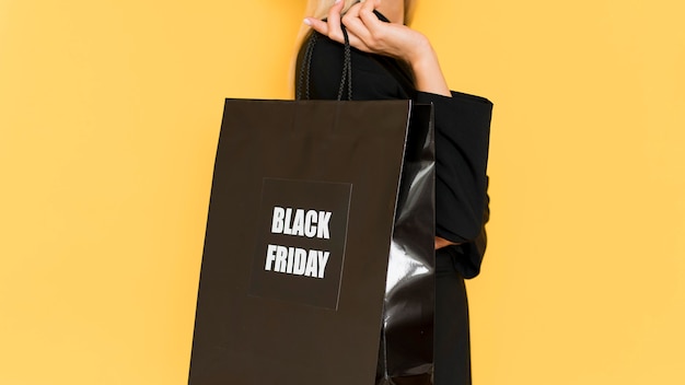 Photo gratuite sidways woman holding shopping noir pour le vendredi noir