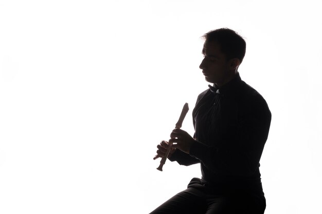 Silhouette d'un artiste jouant de la flûte