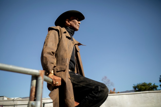 Photo gratuite silhouette de cow-boy contre une lumière chaude