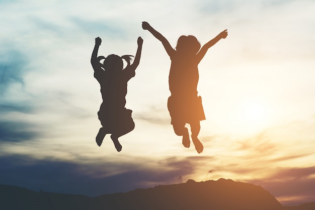 Silhouette de deux fille s&#39;amuser dans la nature