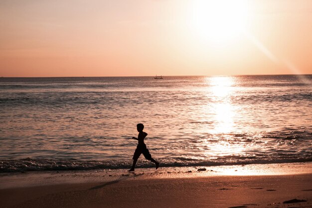 Silhouette d'enfants sur Belle vue sur le ciel au coucher du soleil sur la plage