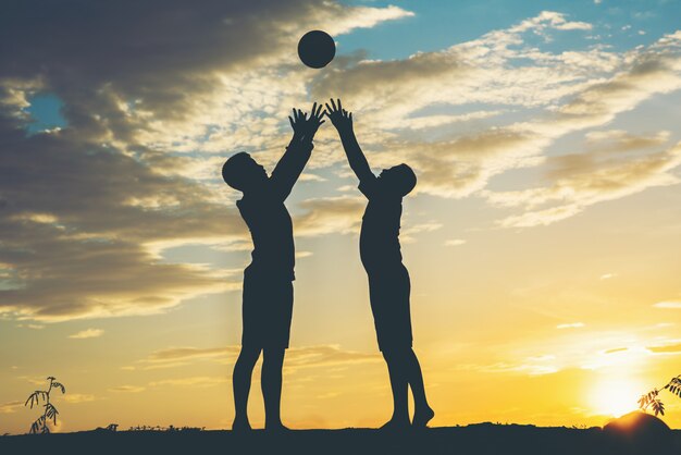 Silhouette d&#39;enfants jouant au football