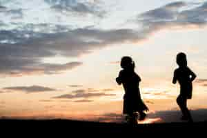 Photo gratuite silhouette d'enfants jouant