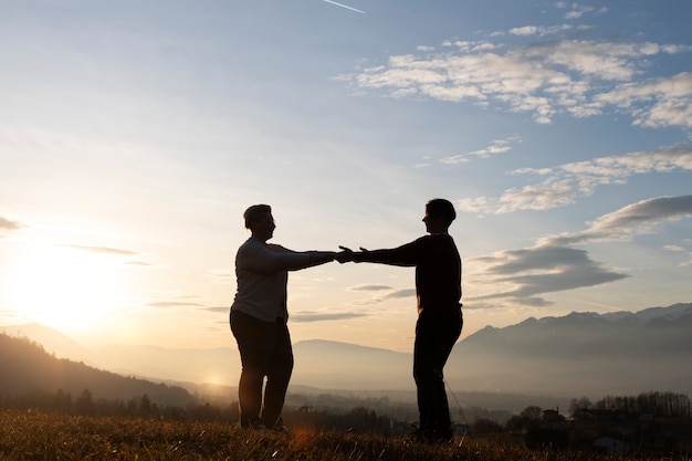 Photo gratuite silhouette familiale complète dans la nature au coucher du soleil