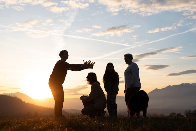 Silhouette familiale complète dans la nature au coucher du soleil