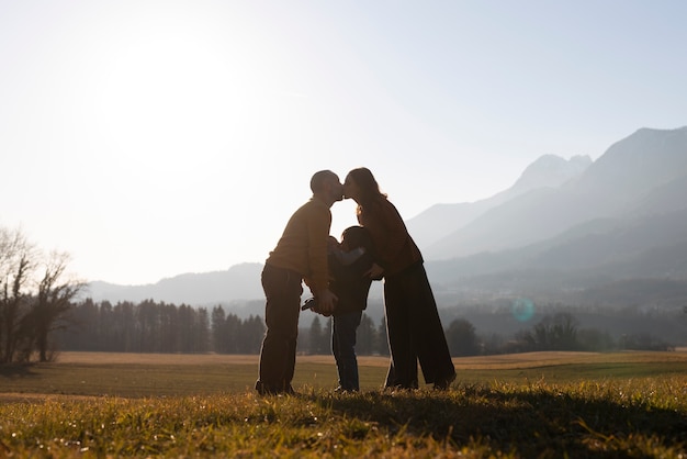 Photo gratuite silhouette familiale complète dans la nature au coucher du soleil