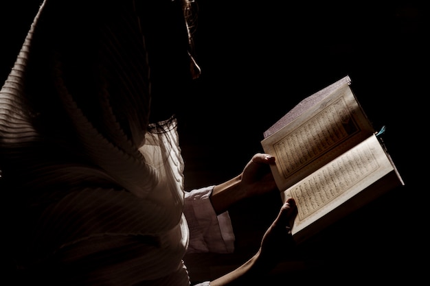 Silhouette de femme lisant en coran