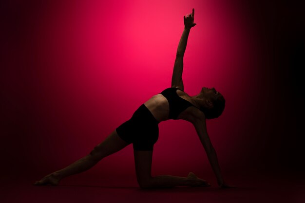 Silhouette de femme plein coup posant avec une lumière rouge