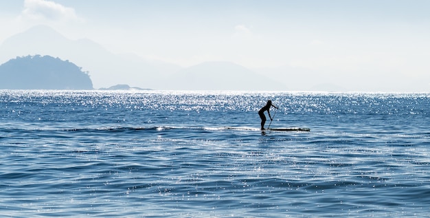 Silhouette d'une femme stand up paddle surf à la mer au Brésil