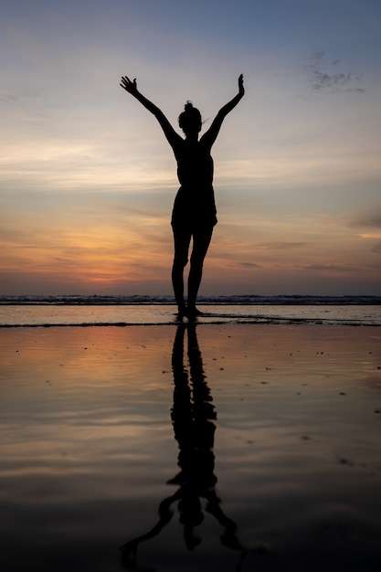 Silhouette, girl, debout, eau, bras, élevé