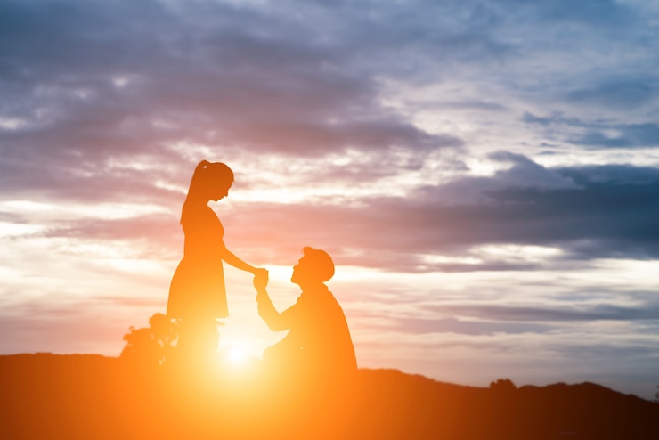 Photo gratuit silhouette de l&#39;homme demande femme de se marier sur fond de montagne.