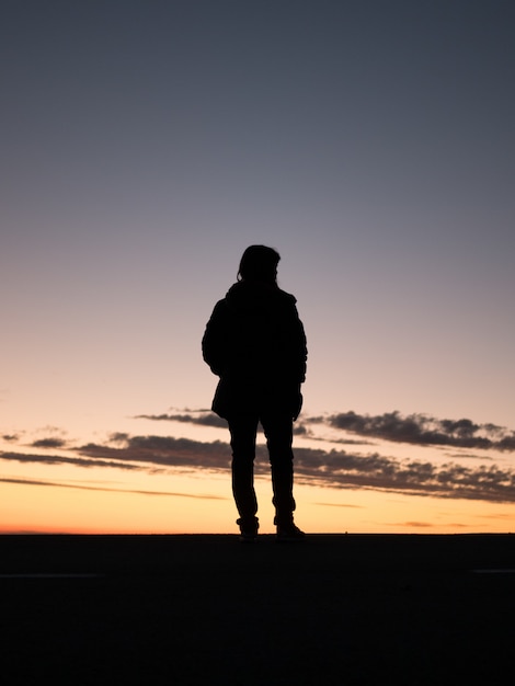 Silhouette d'une personne solitaire profitant de la belle vue sur le coucher du soleil