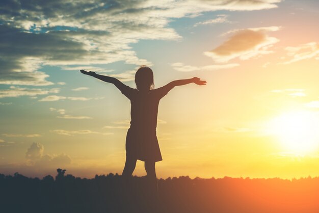 Silhouette, de, petite fille, élever main, à, temps heureux liberté