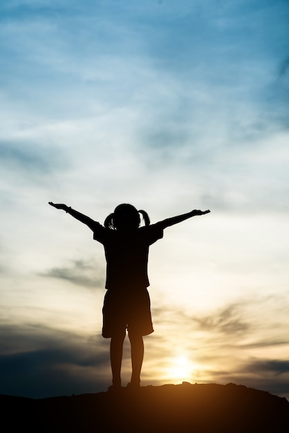 Silhouette, de, petite fille, élever main, à, temps heureux liberté