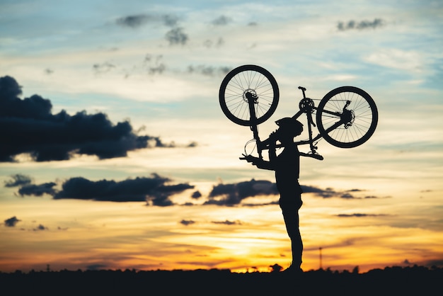 Silhouette de repos cycliste au coucher du soleil. concept de sport de plein air actif