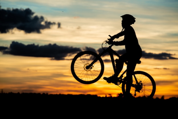 Silhouette de repos cycliste au coucher du soleil. concept de sport de plein air actif