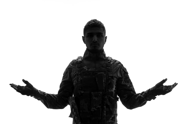 Silhouette de soldat sérieux beau soldat de l'armée solide et dur en uniforme agitant les mains