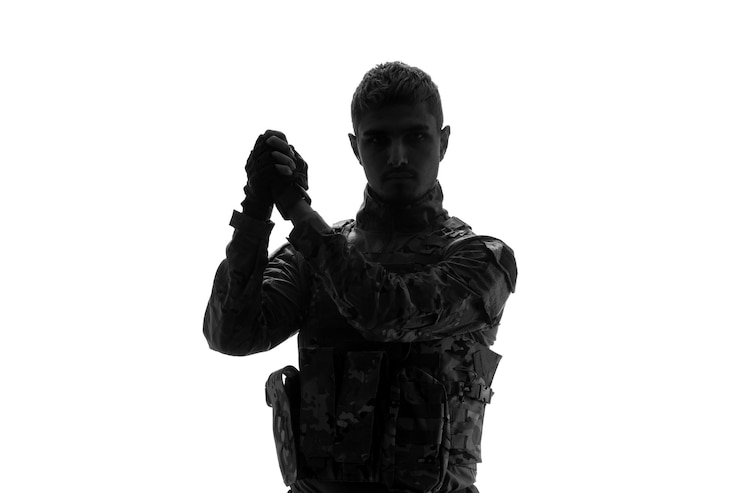 Photo gratuit silhouette de soldat sérieux beau soldat de l'armée solide et solide en uniforme tenant les mains ensemble