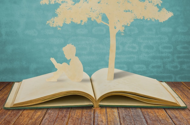 Photo gratuite silhouettes d'un arbre et un homme sur un livre