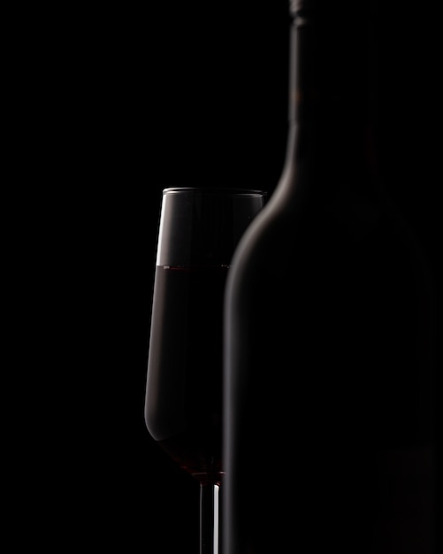 Silhouettes de bouteille de vin et verre à vin sur fond noir