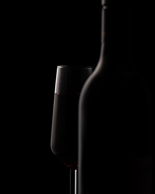 Silhouettes de bouteille de vin et verre à vin sur fond noir
