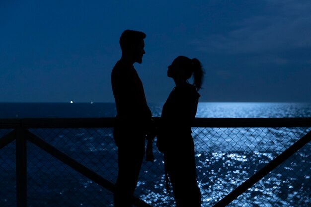 Silhouettes noires d'un couple d'amoureux se regardant