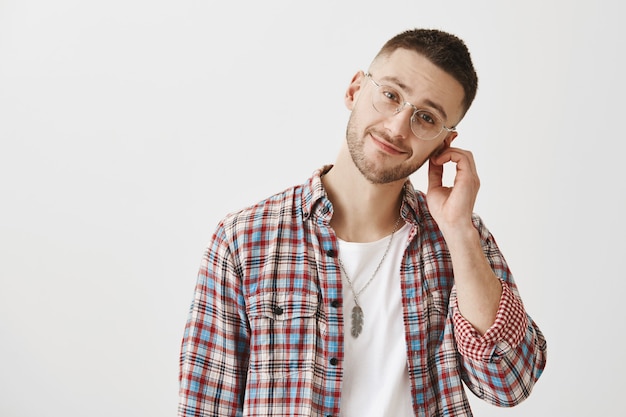 Silly beau jeune homme avec des lunettes posant