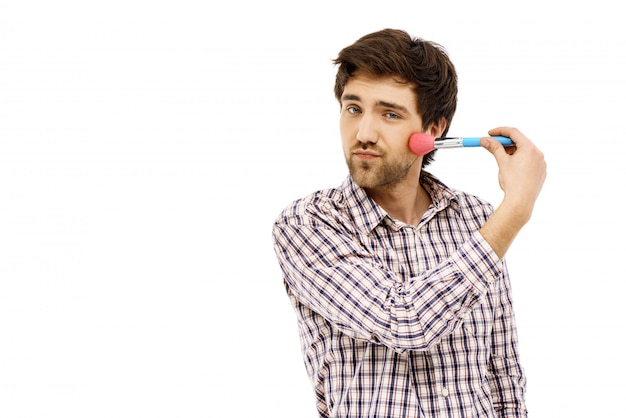 Silly guy appliquer du maquillage fard à joues avec une brosse