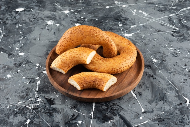 Simit de bagel traditionnel turc dans une assiette en bois sur un fond de marbre.