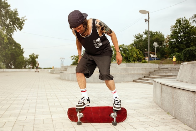 Photo gratuite skateur faisant un tour dans la rue de la ville en journée nuageuse