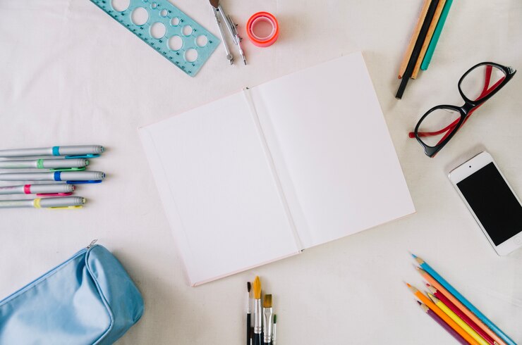Photo gratuit sketchbook au milieu de la composition de papeterie