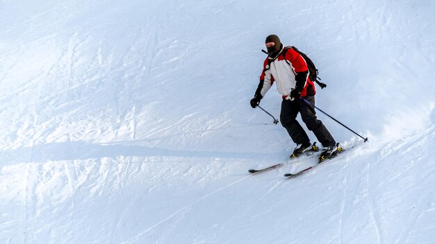 Skieur à cheval sur une piste de ski dans les Carpates en hiver Roumanie