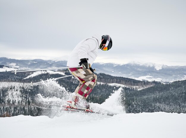 Skieur masculin skiant dans de belles montagnes d'hiver