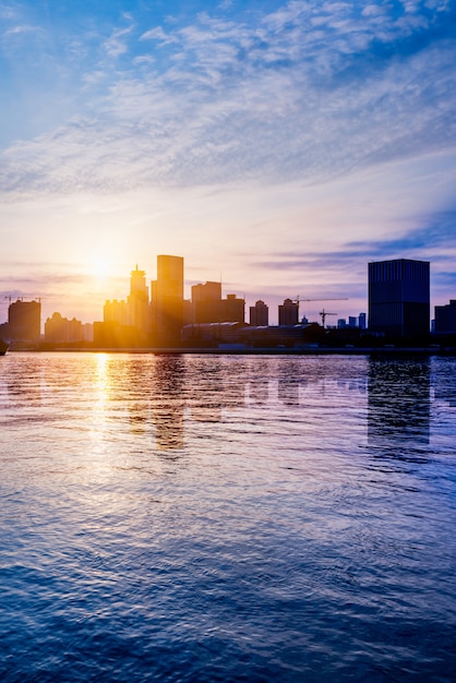 Photo gratuite skyline de la ville par la rivière contre le ciel nuageux