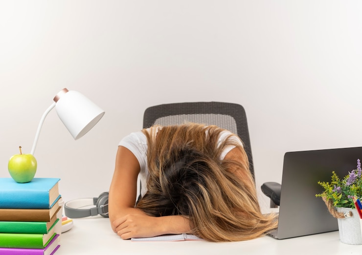 Photo gratuit sleepy young jolie étudiante dormir au bureau avec des outils scolaires isolé sur un mur blanc