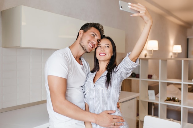 Slim femme brune faisant selfie avec son mari avant le petit déjeuner