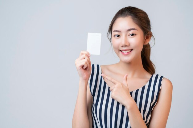 Smart casual asian beau sourire féminin montre une carte de modèle vierge avec un fond blanc joyeux