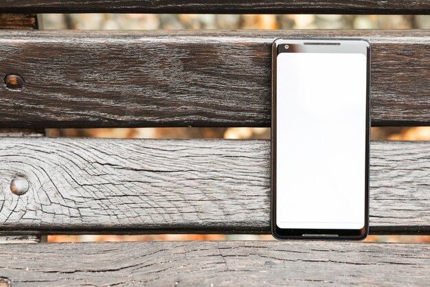 Smartphone avec un écran blanc sur une planche en bois