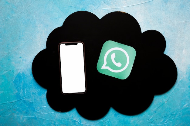 Smartphone et icône de médias sur un nuage noir sur le mur bleu peint