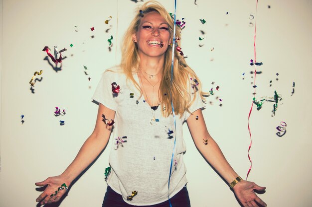 Smiley blonde posant avec des confettis